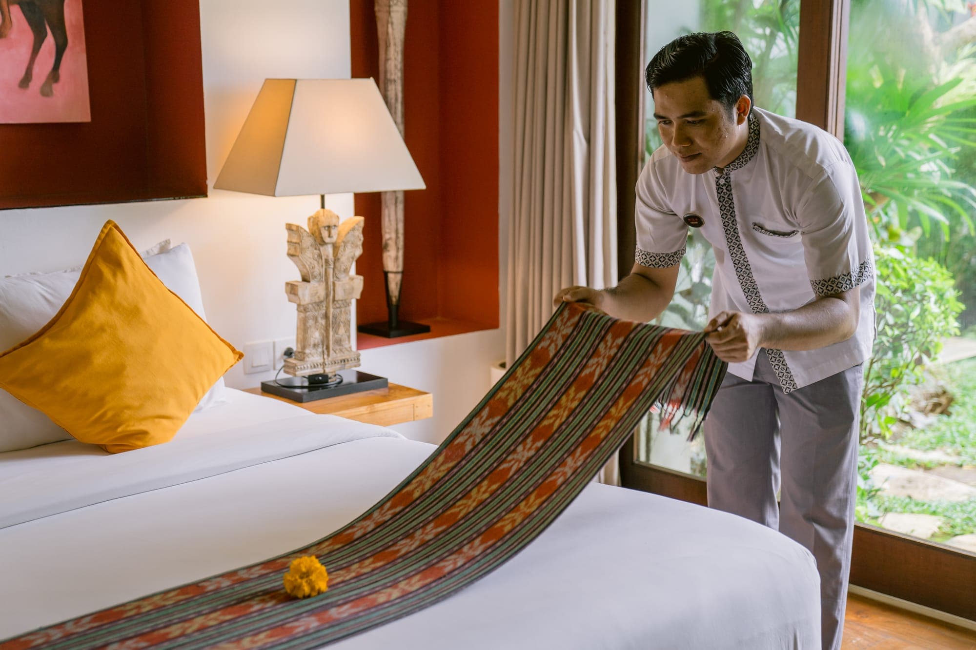 An Anam Villa butler arranging fresh towels in a guest suite
