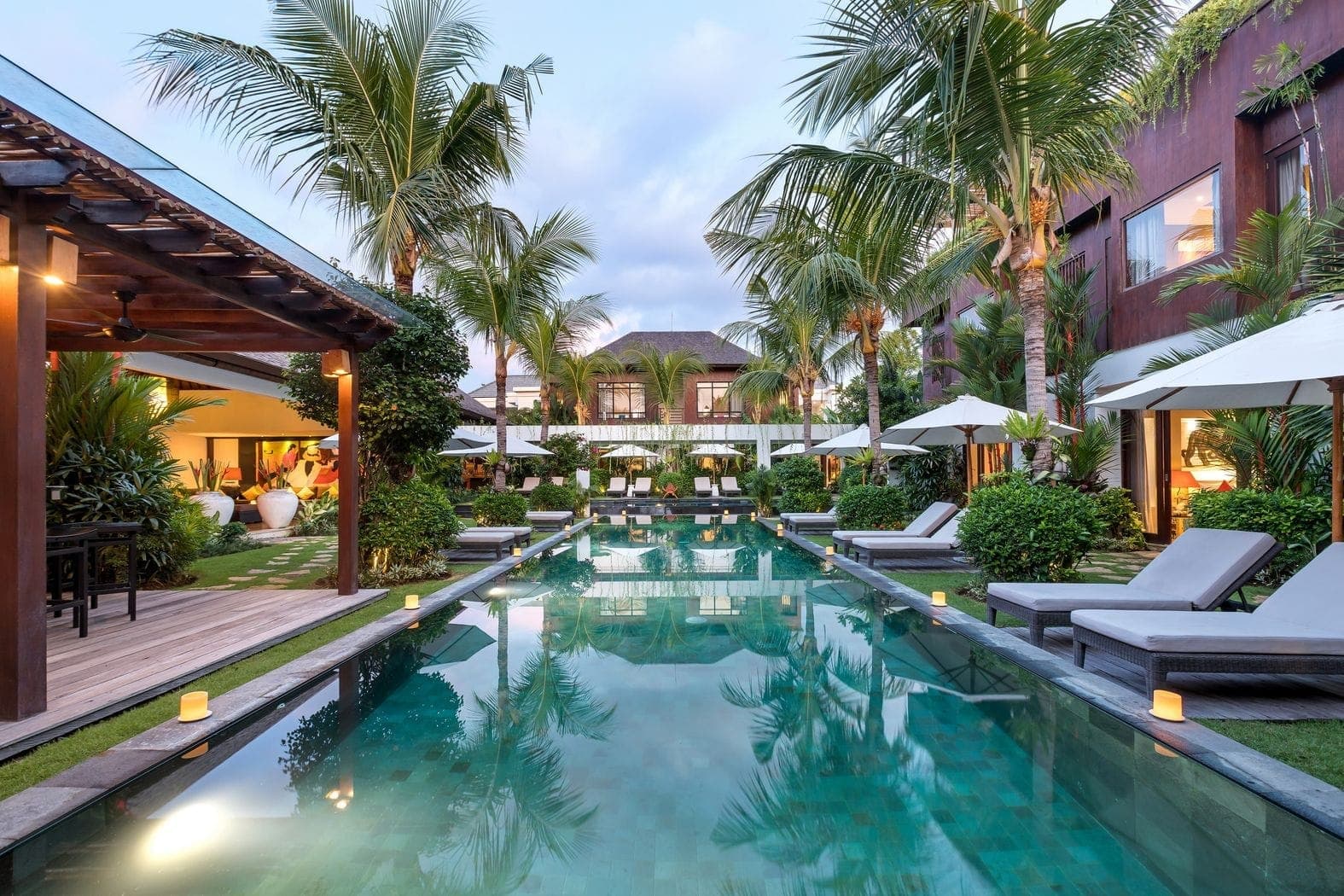 Anam Villa's pool at dusk, lit for the evening